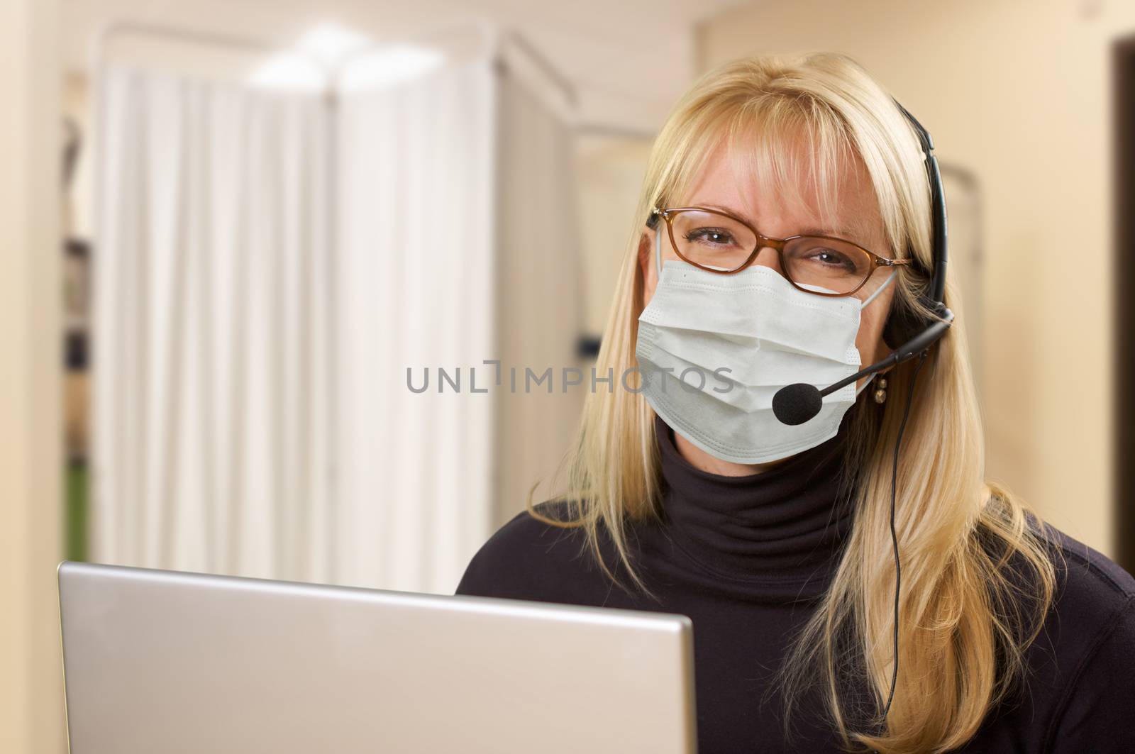 Woman At Medical Office Desk Wearing Face Mask.