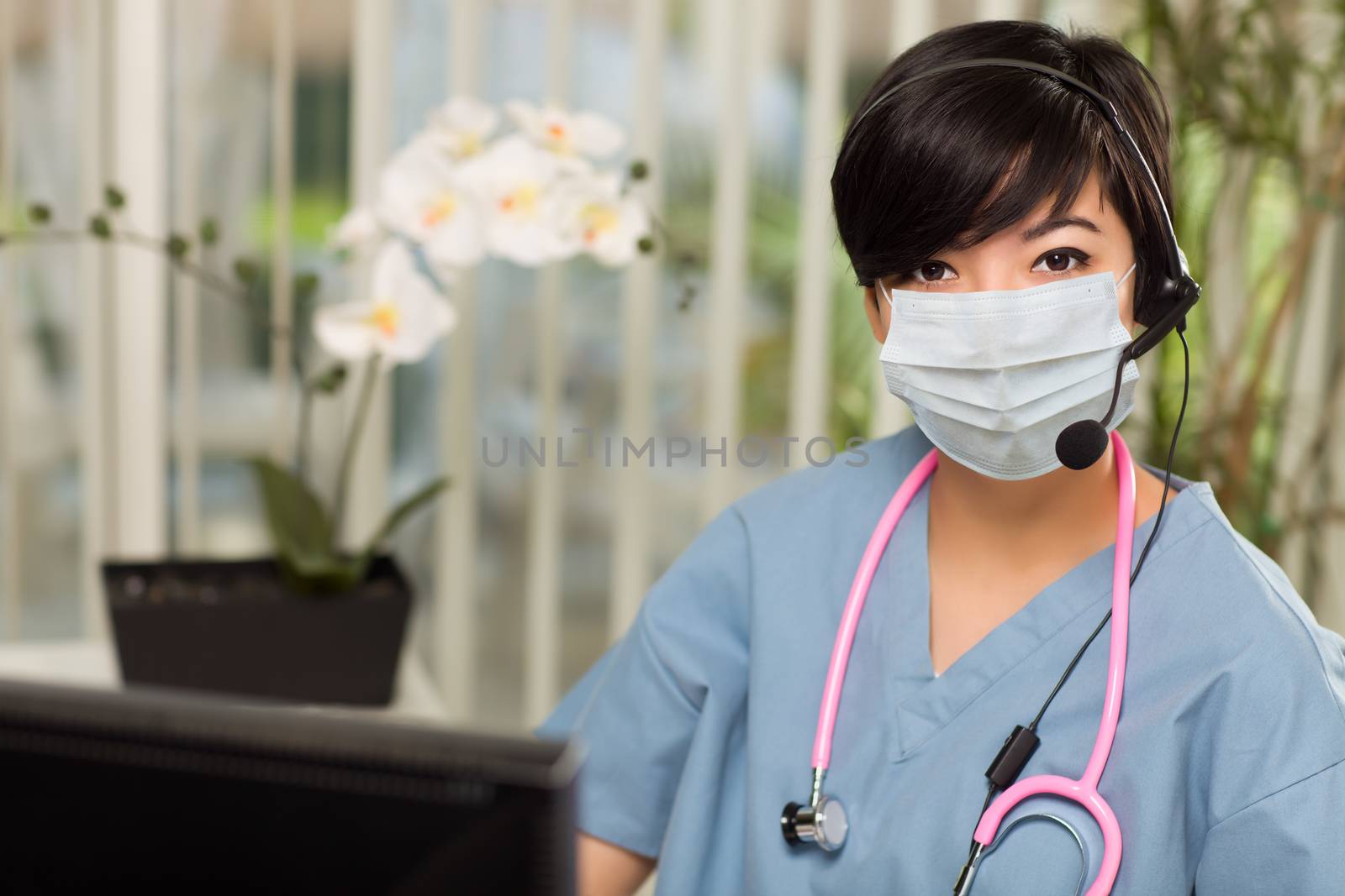 Nurse At Office Desk Wearing Medical Face Mask.