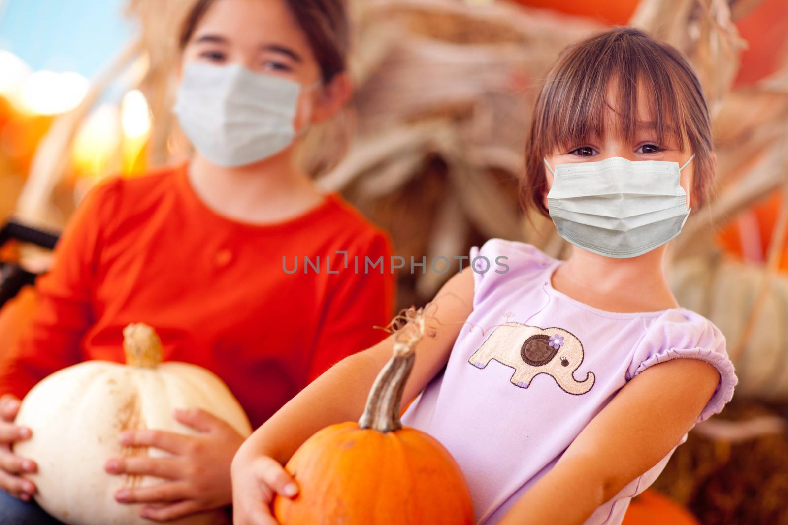 Cute Little Girls Holding Their Pumpkins At A Pumpkin Patch Wearing Medical Face Masks.