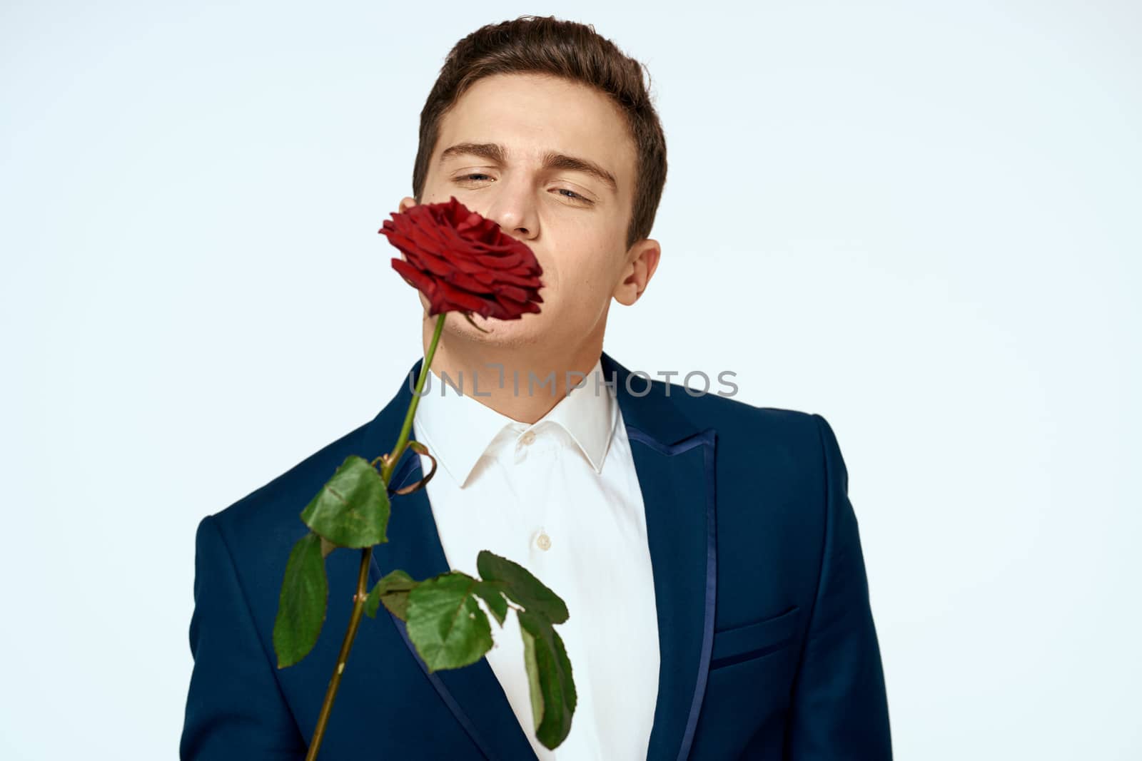 A man in a suit with a rose in his hands a gift date light background by SHOTPRIME
