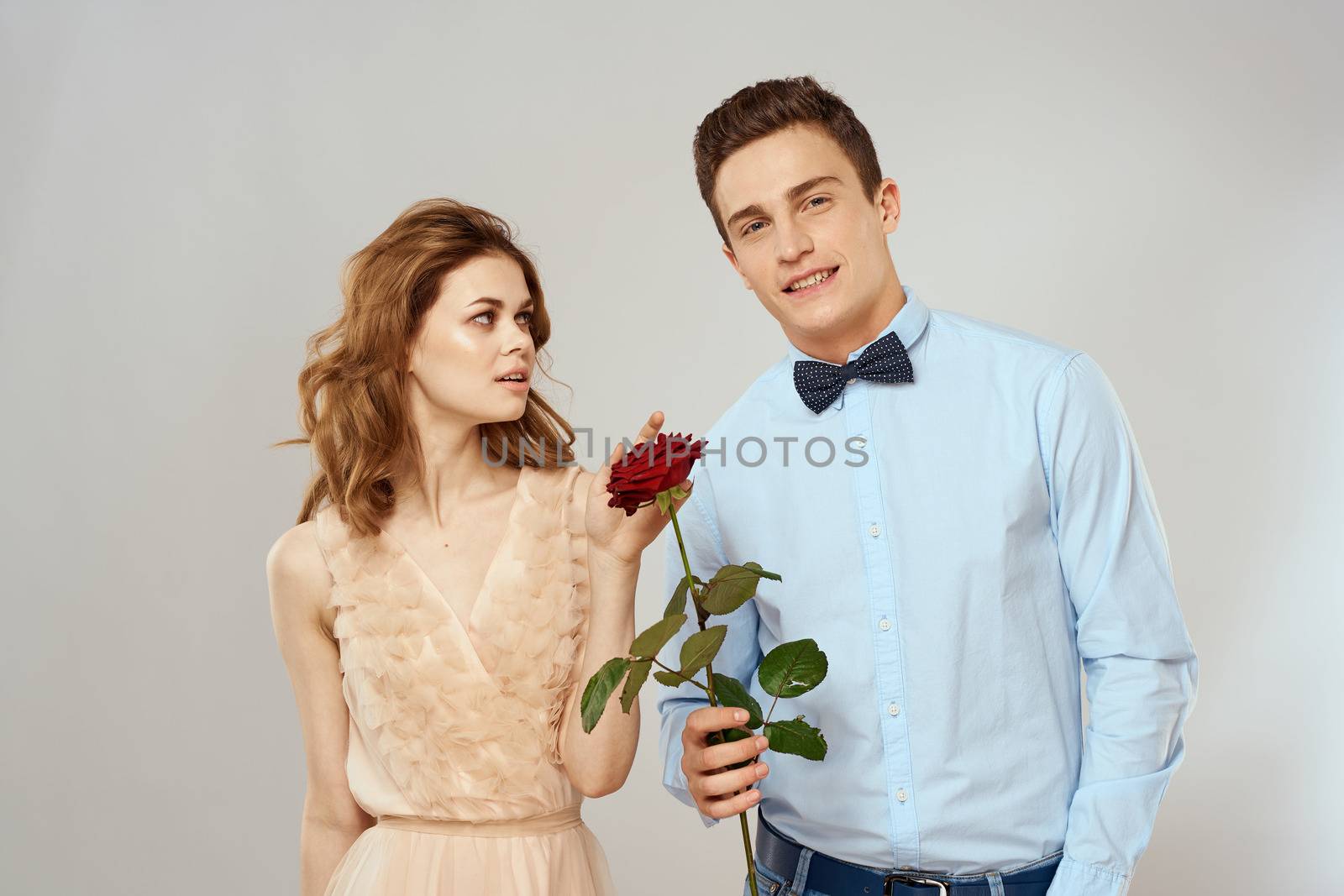 Young couple hugs romance dating lifestyle relationship light background red rose by SHOTPRIME