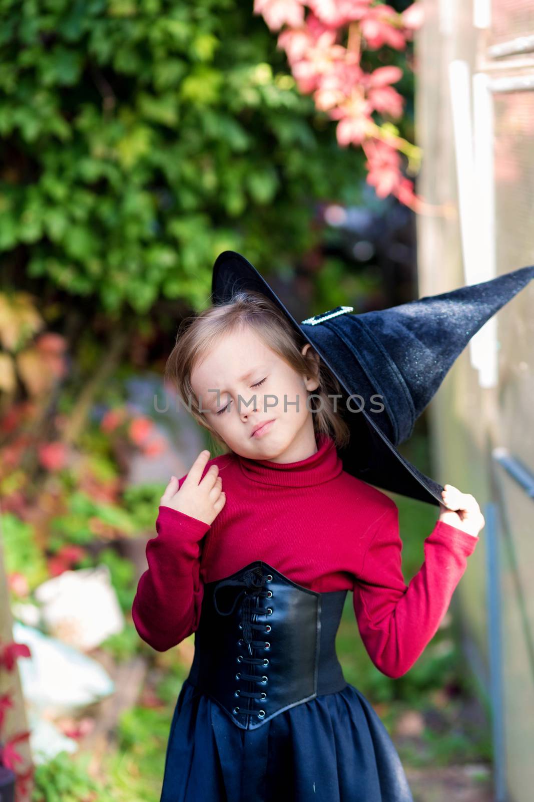 Little girl in witch costume posing on halloween party. by galinasharapova