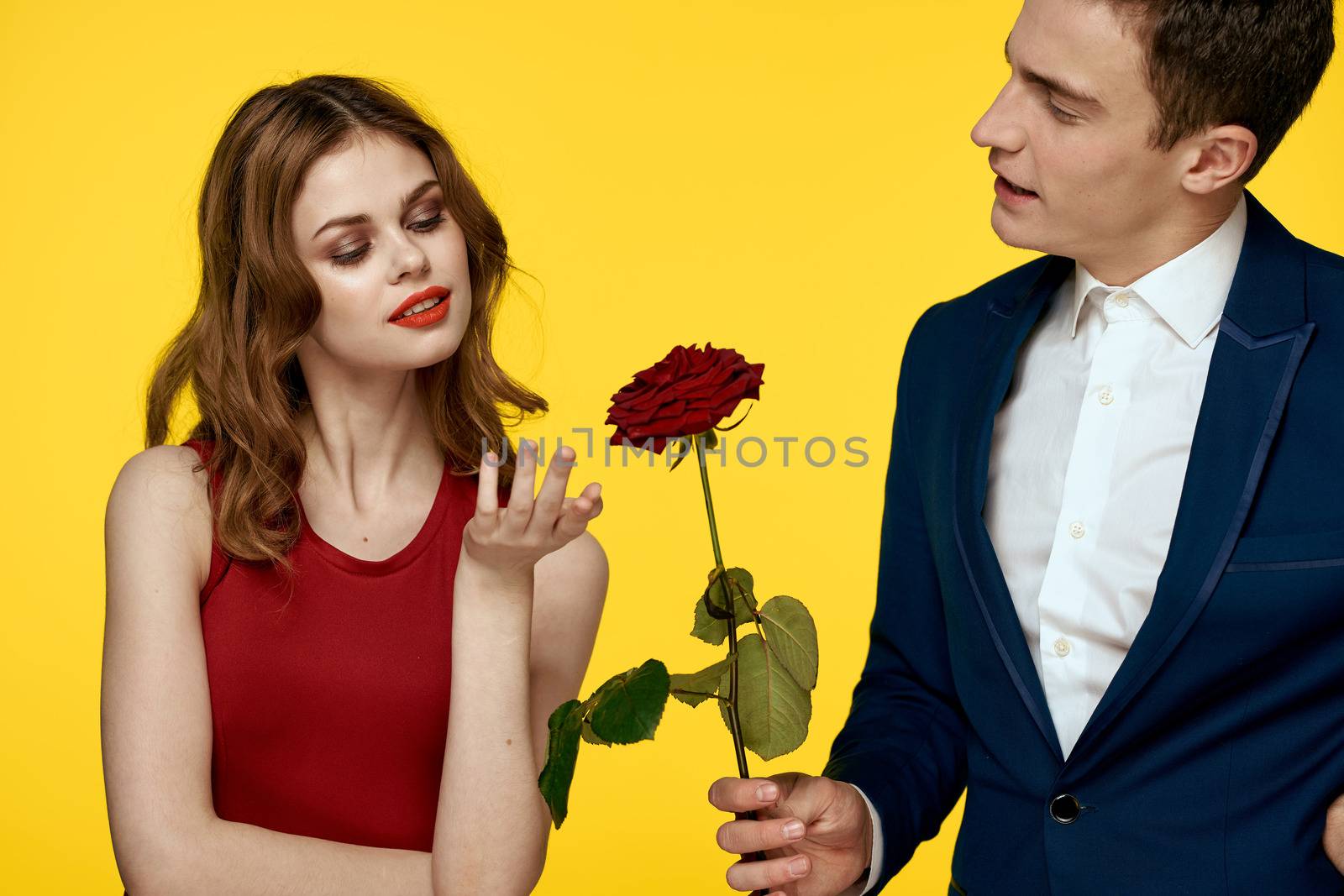 Young charming couple rose relationship romance gift as a lifestyle yellow isolated background by SHOTPRIME