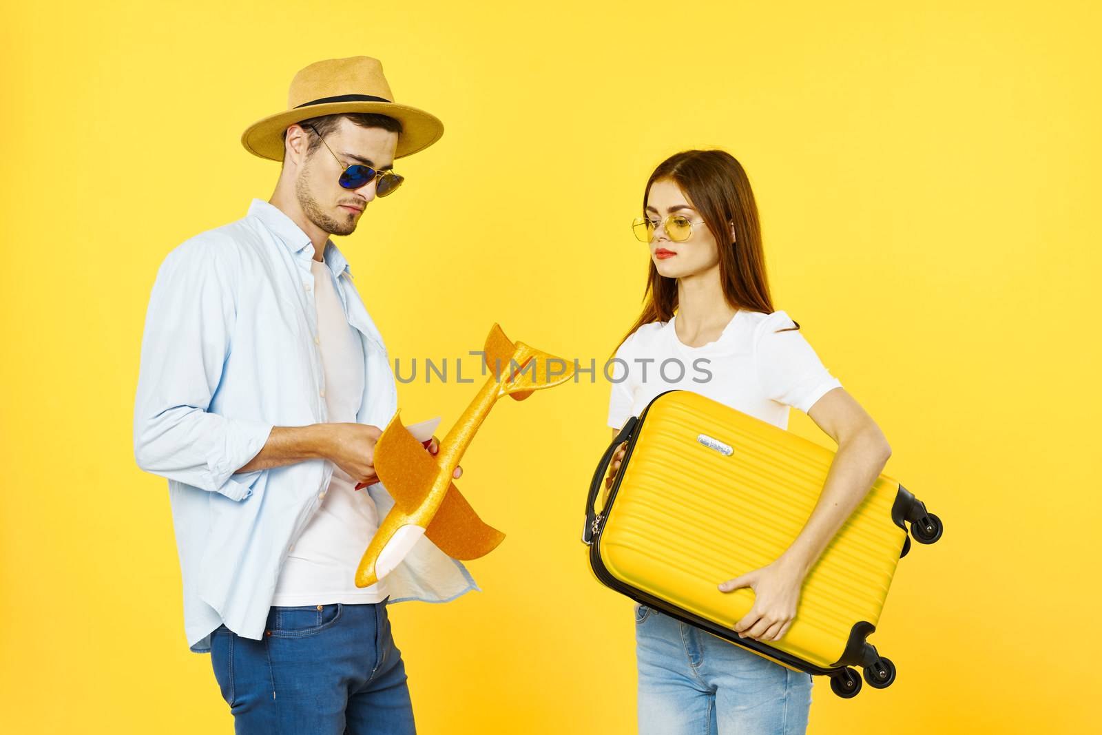 Man and woman tourists airplane travel passenger baggage airport yellow background