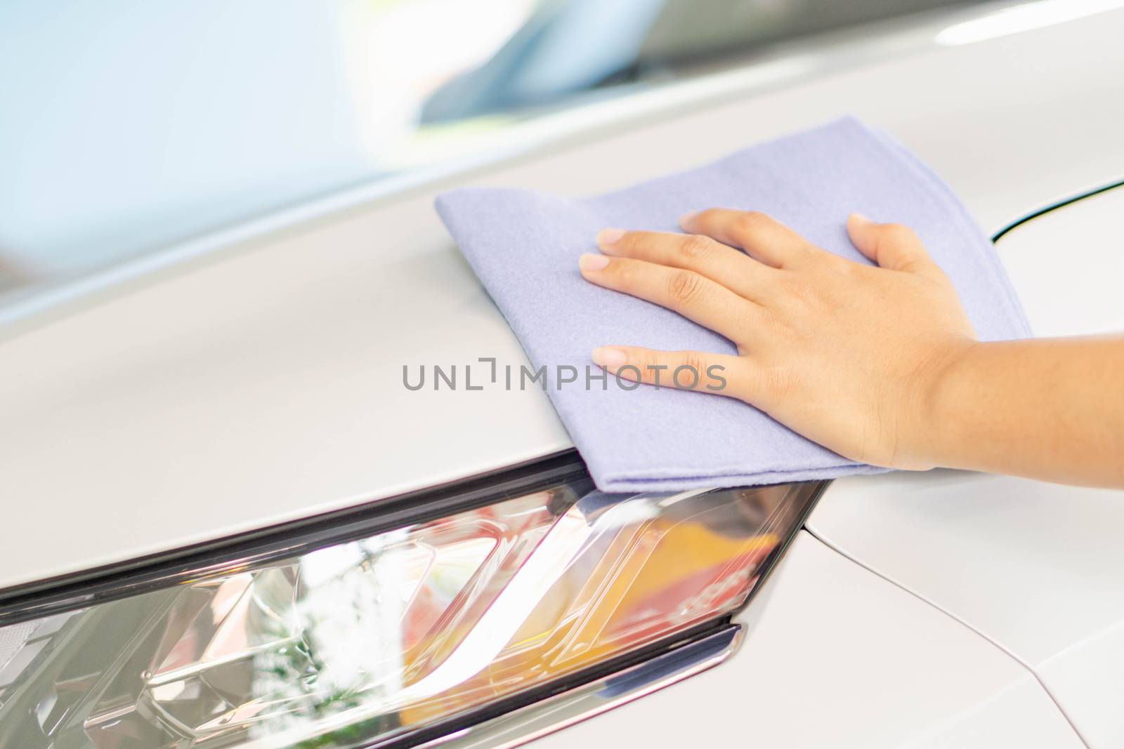 Man cleaning car with microfiber cloth, car detailing (or valeting) concept. Selective focus.