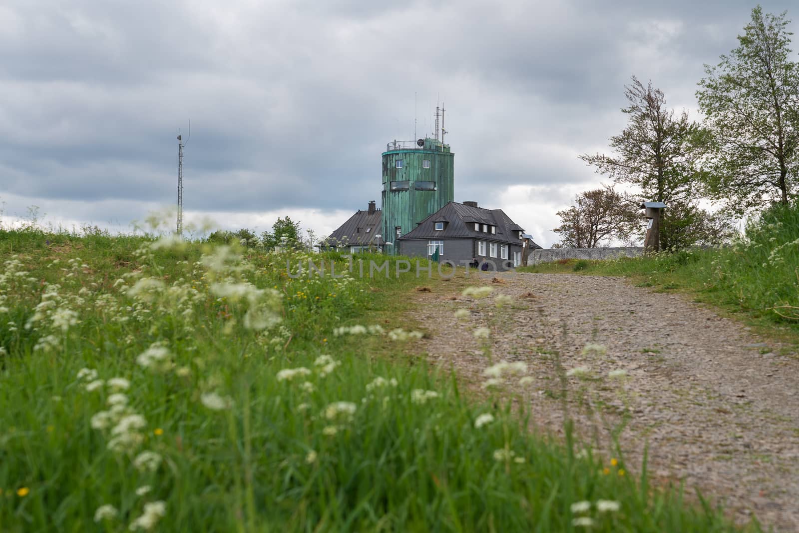 WINTERBERG, GERMANY - JUNE 7, 2020: People on a hiking trail crossing the peak of the Kahler Asten, most famous mountain of Sauerland region on June 7, 2020 in Germany