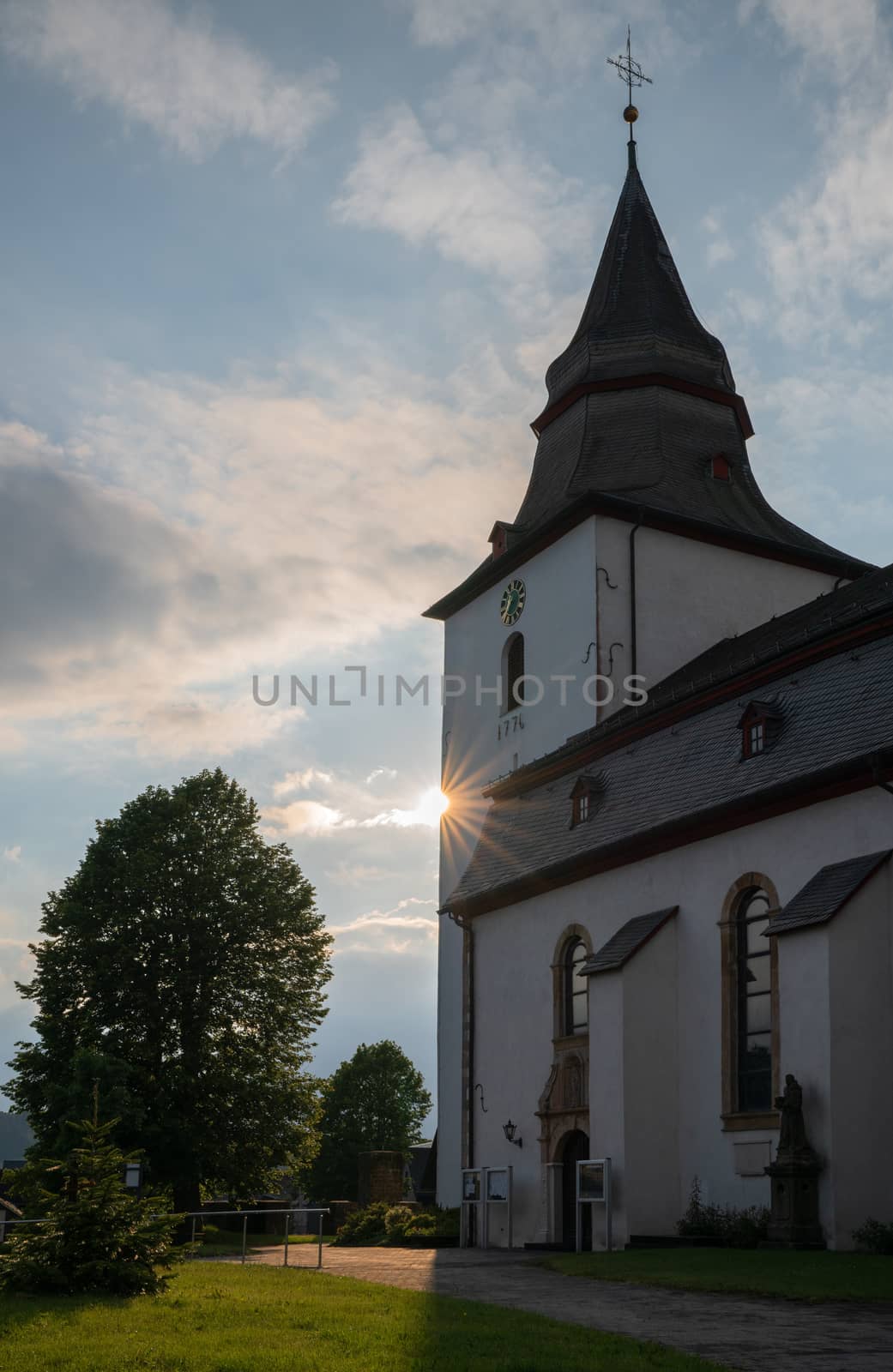 Atmospheric image of the Parish church of Winterberg at sunset with evening sun