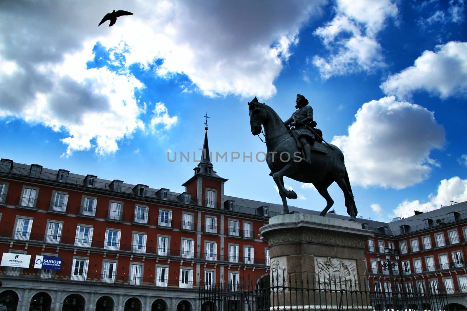 Beautiful equestrian statue of Felipe III in the main square in Madrid called Plaza Mayor with its majestic facades in a sunny day of Spring