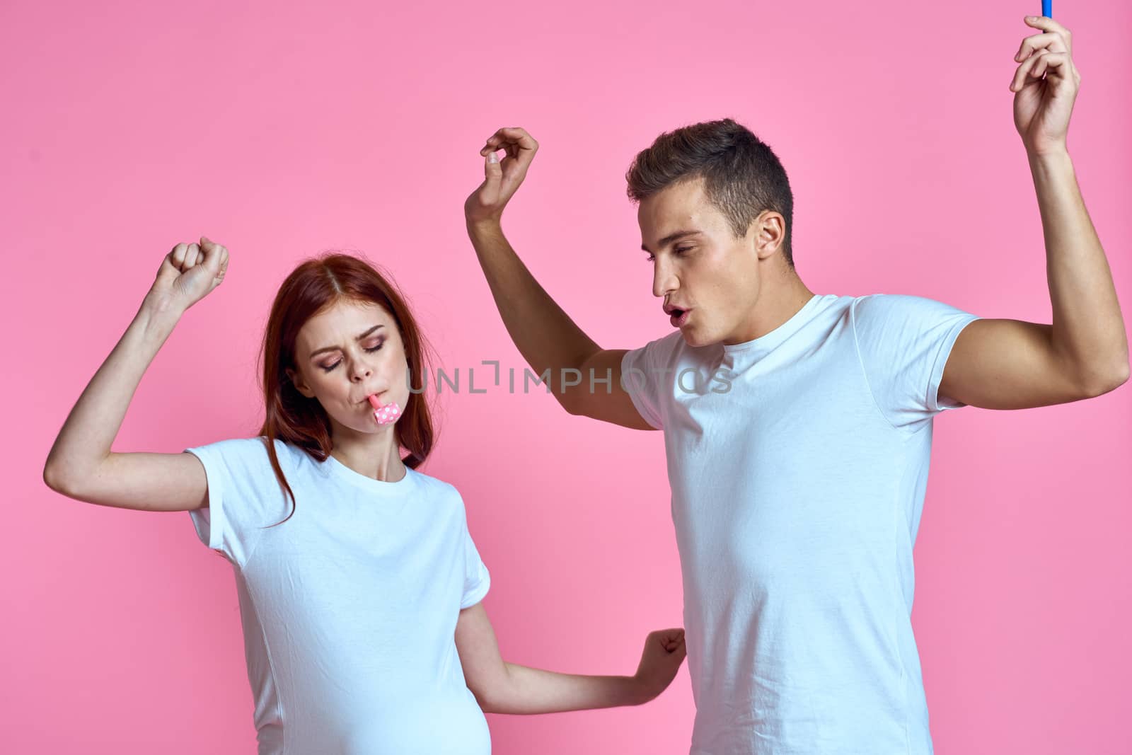 pregnant mom and happy father on pink background Young family waiting for baby. High quality photo