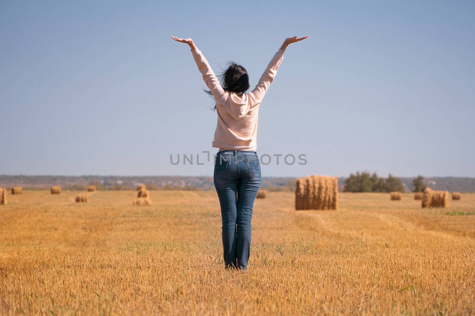 A happy, free, independent, dreamy girl in the field raised her  by YevgeniySam