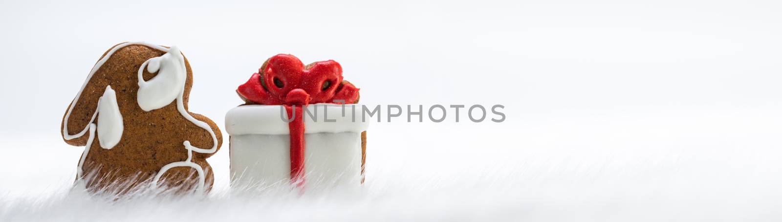 Gingerbread cookies rabbit and gift in snow isolated on white background