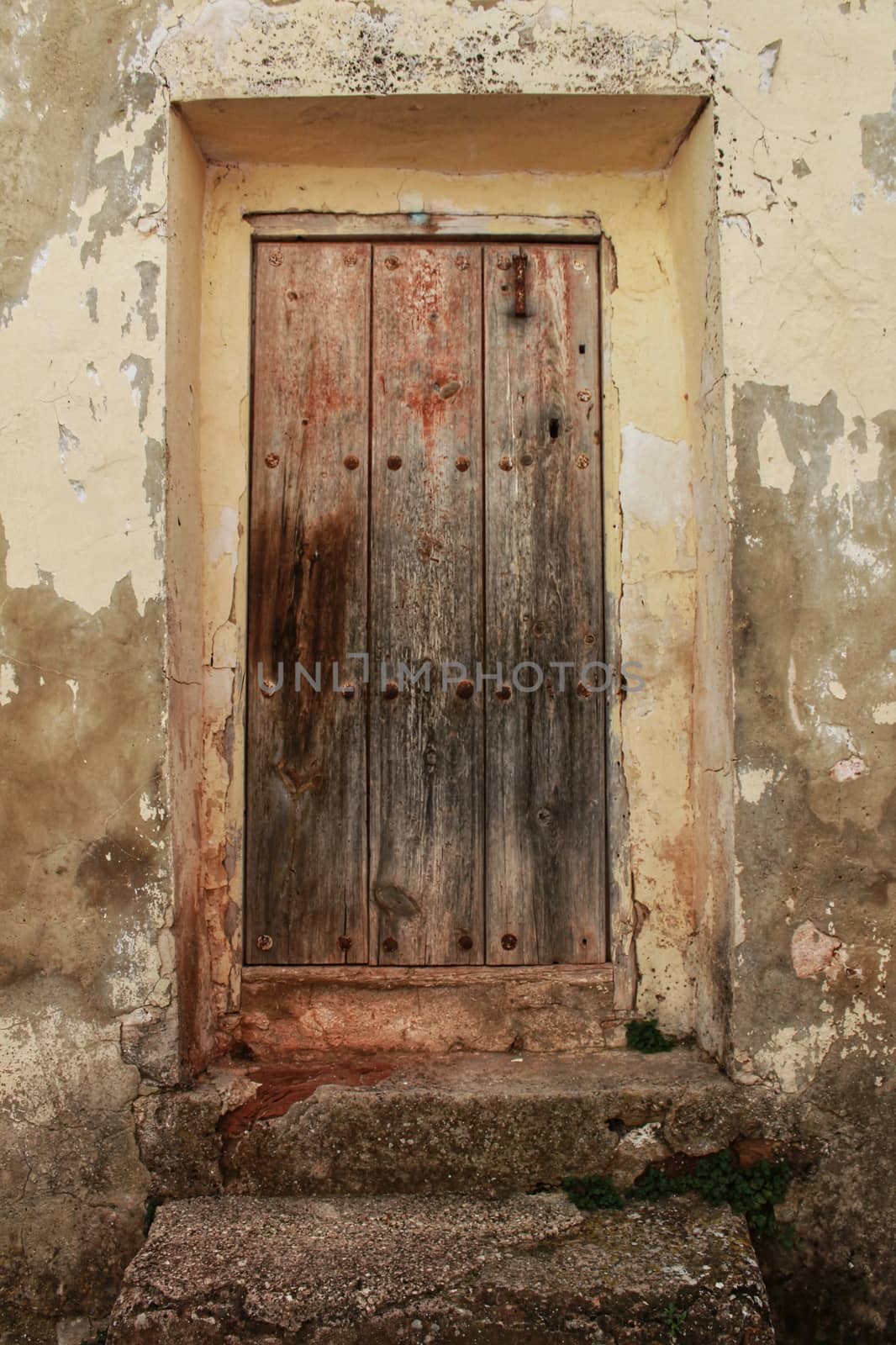 Old wooden door with wrought iron details by soniabonet