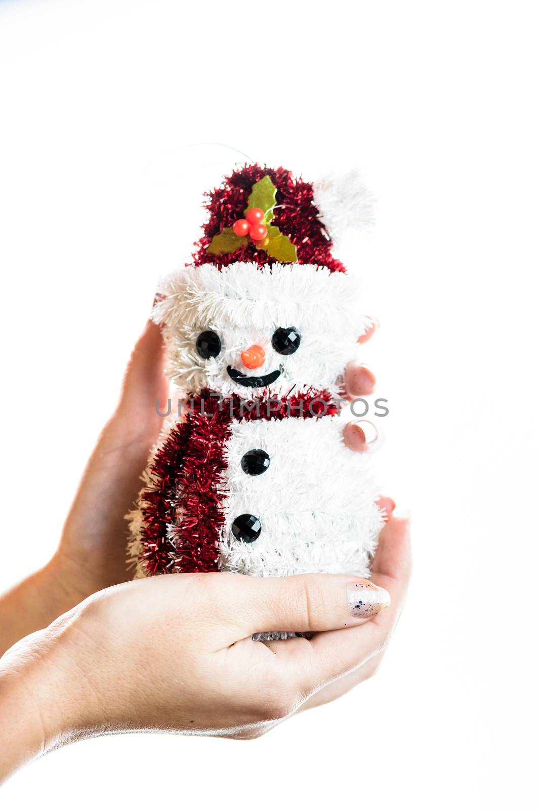 Hand holding Christmas snowman figurine isolated on white backgr by vladispas