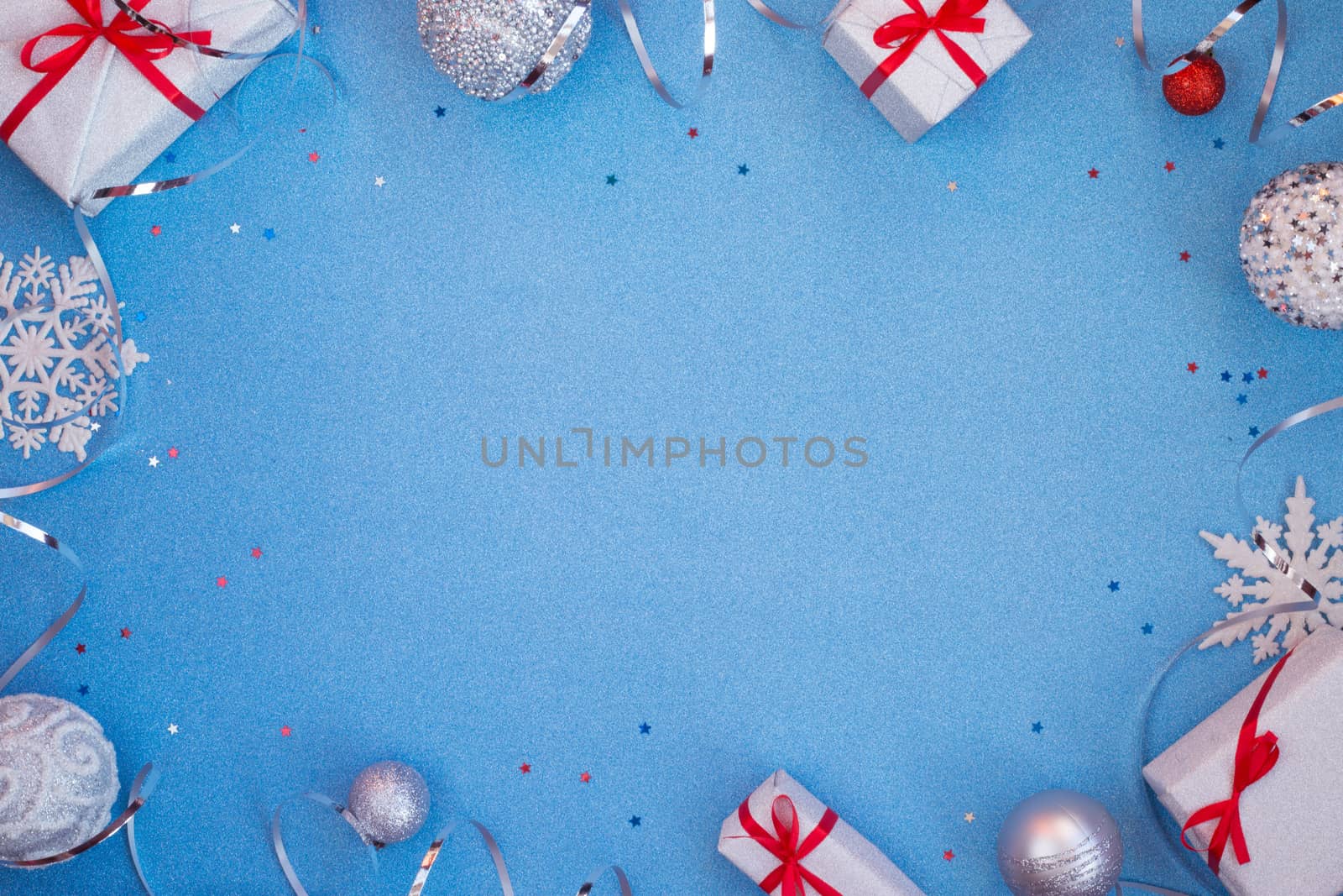 Blue glitter texture christmas background and silver gifts with red ribbon bow baubles snowflakes and ribbons , copy space for text , top view flat lay template