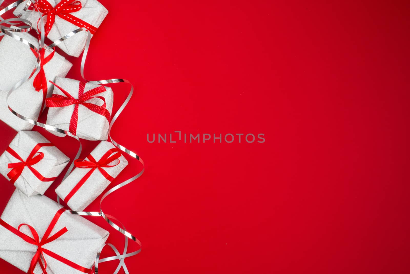 Heap of many different gifts for christmas or valentines day birthday holiday on red paper background with copy space for text