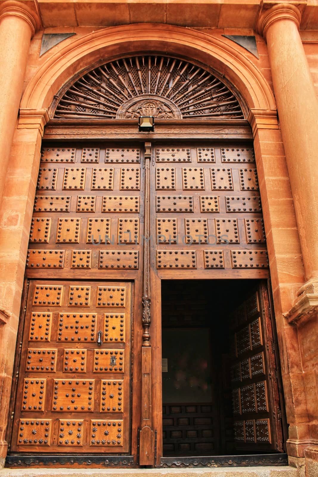 Old stone facade made of carved stone and vintage wooden door in a majestic house in Villanueva de los Infantes, Ciudad Real community, Spain.