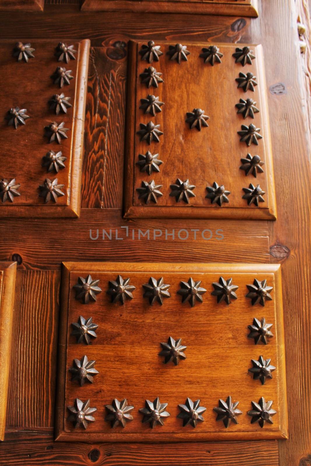 Old wooden door with wrought iron details with the shape of a star in Villanueva de Los Infantes village, Spain