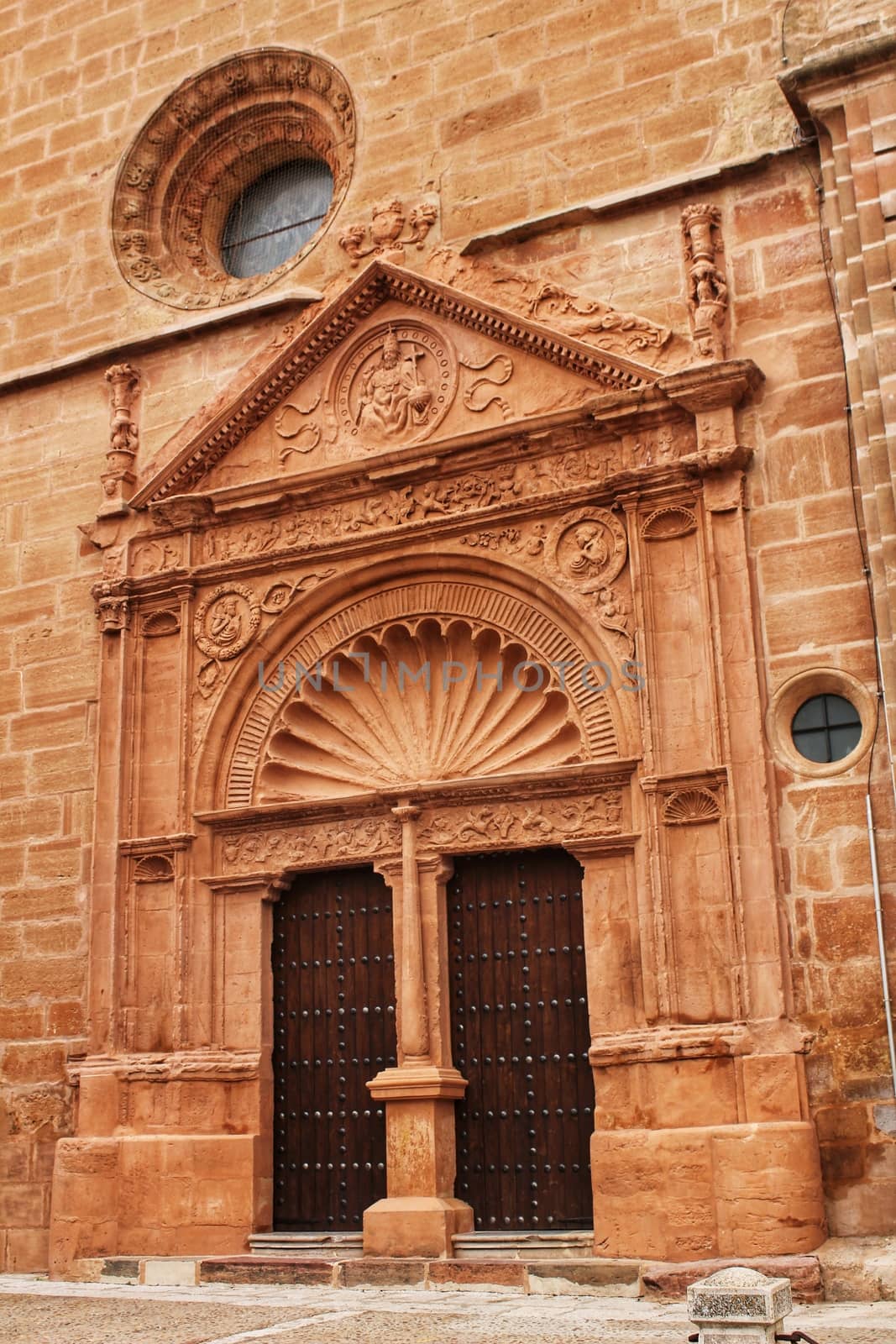 Old stone facade made of carved stone and vintage wooden door in a majestic house in Villanueva de los Infantes, Ciudad Real community, Spain. Encarnacion convent facade.