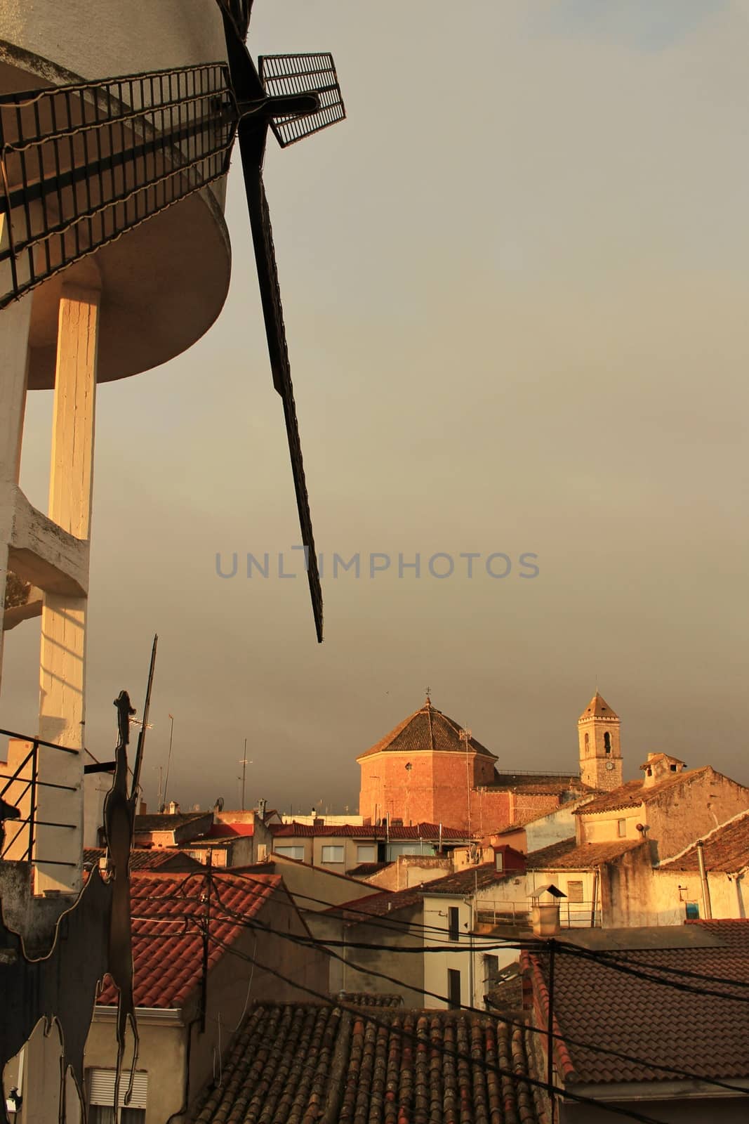 Panoramic of Alborea village at sunrise. Old church in the background and windmill in the foreground.