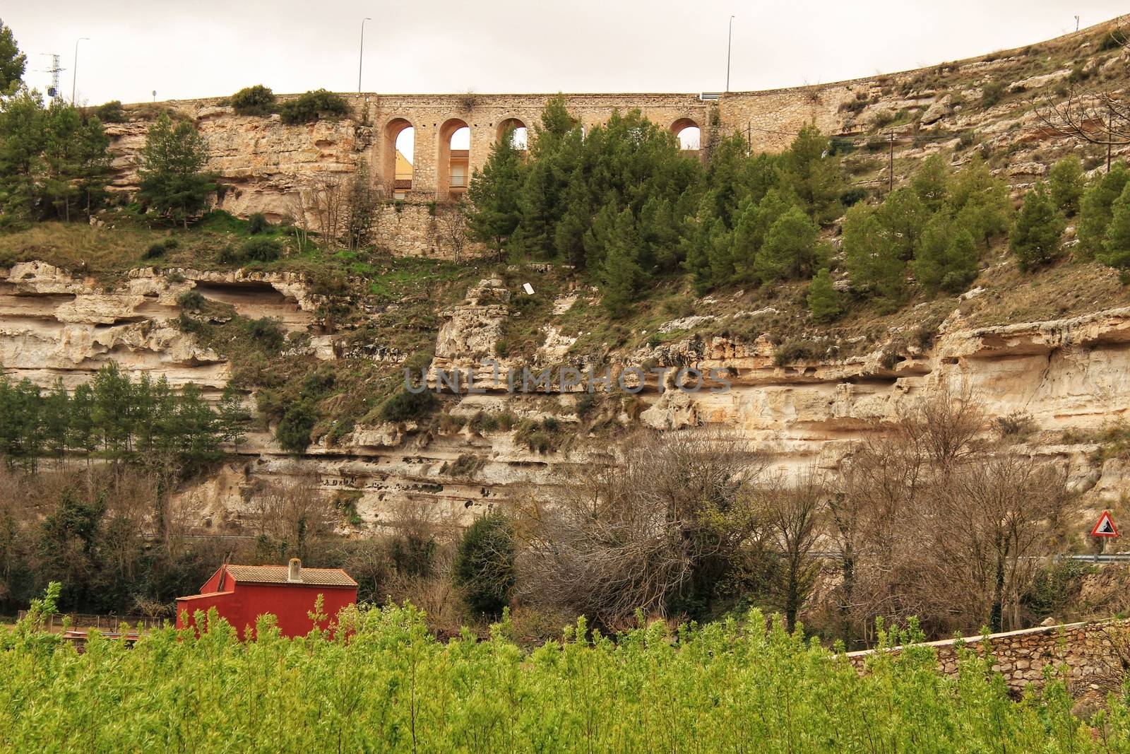 Mountain landscape with wooden house and view of old stone aqueduct in Jorquera, Spain