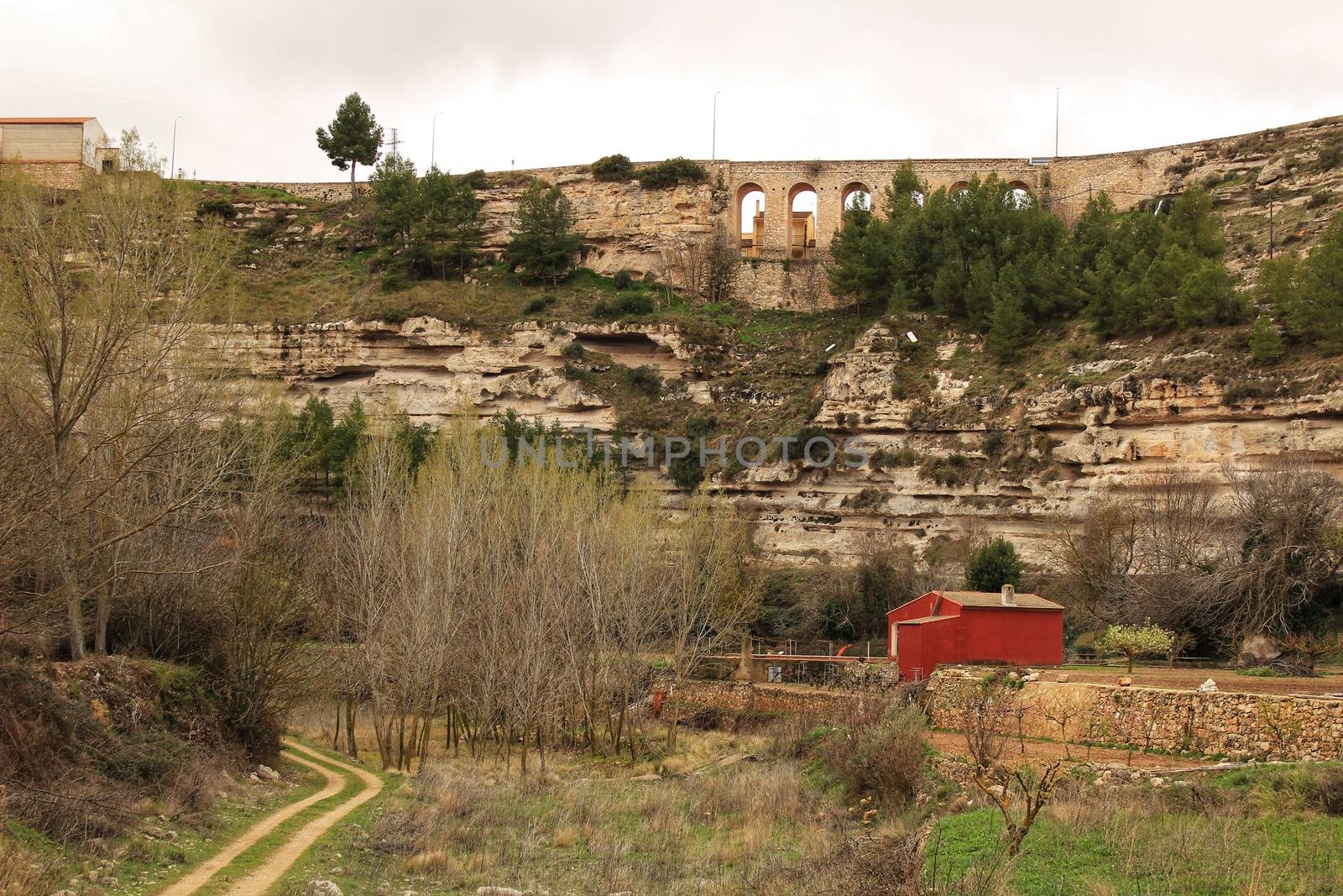 Mountain landscape with wooden house and view of old stone aqueduct by soniabonet