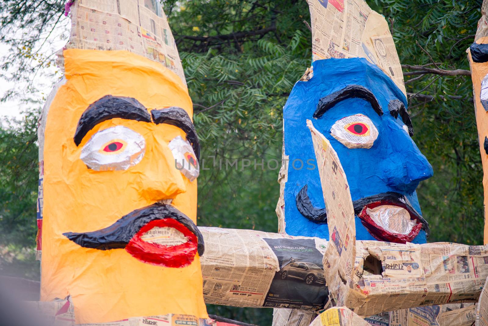 colorful ravana effigies placed on a busy street with traffic passing by to be purchased and filled with fireworks for the hindu festival of dussehra or vijay dashmi celebrating the victory of good over evil as given in the indian epic of ramayana