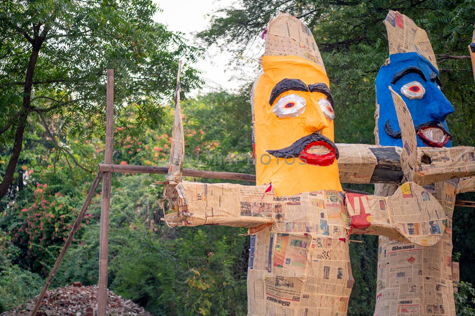 colorful ravana effigies placed on a busy street with traffic passing by to be purchased and filled with fireworks for the hindu festival of dussehra or vijay dashmi celebrating the victory of good over evil as given in the indian epic of ramayana