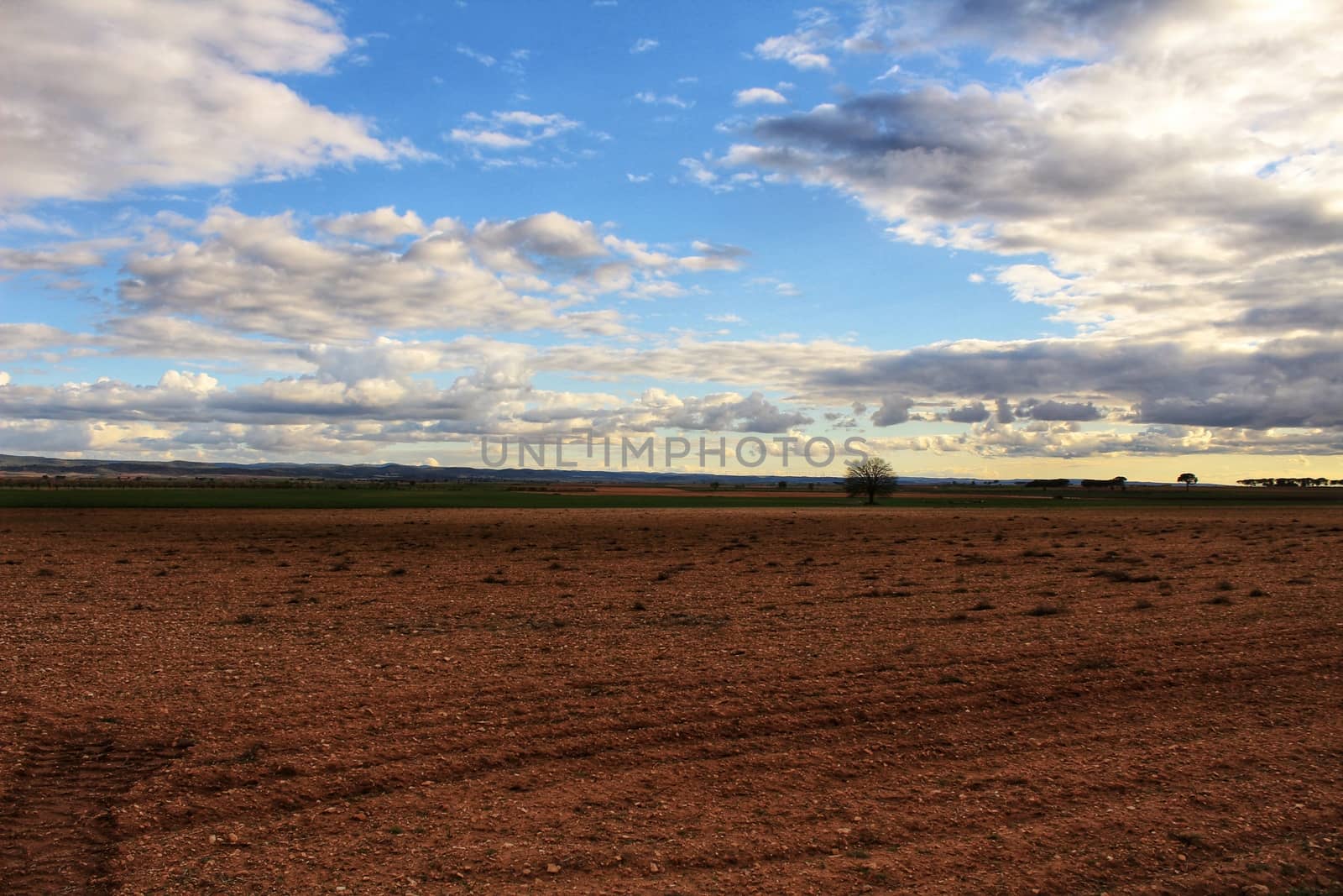 Landscape with cloudy sky and farm field in Castilla La Mancha, Spain