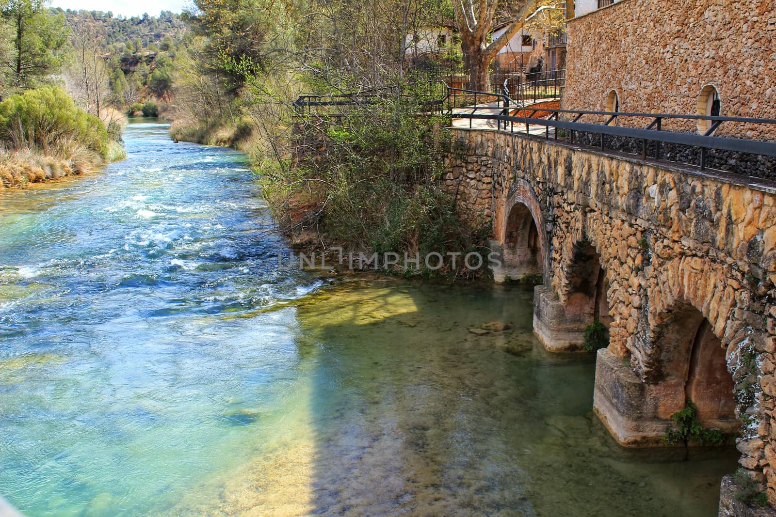 Cabriel River with crystal clear waters and surrounded by green vegetation in the mountains of Albacete, Spain
