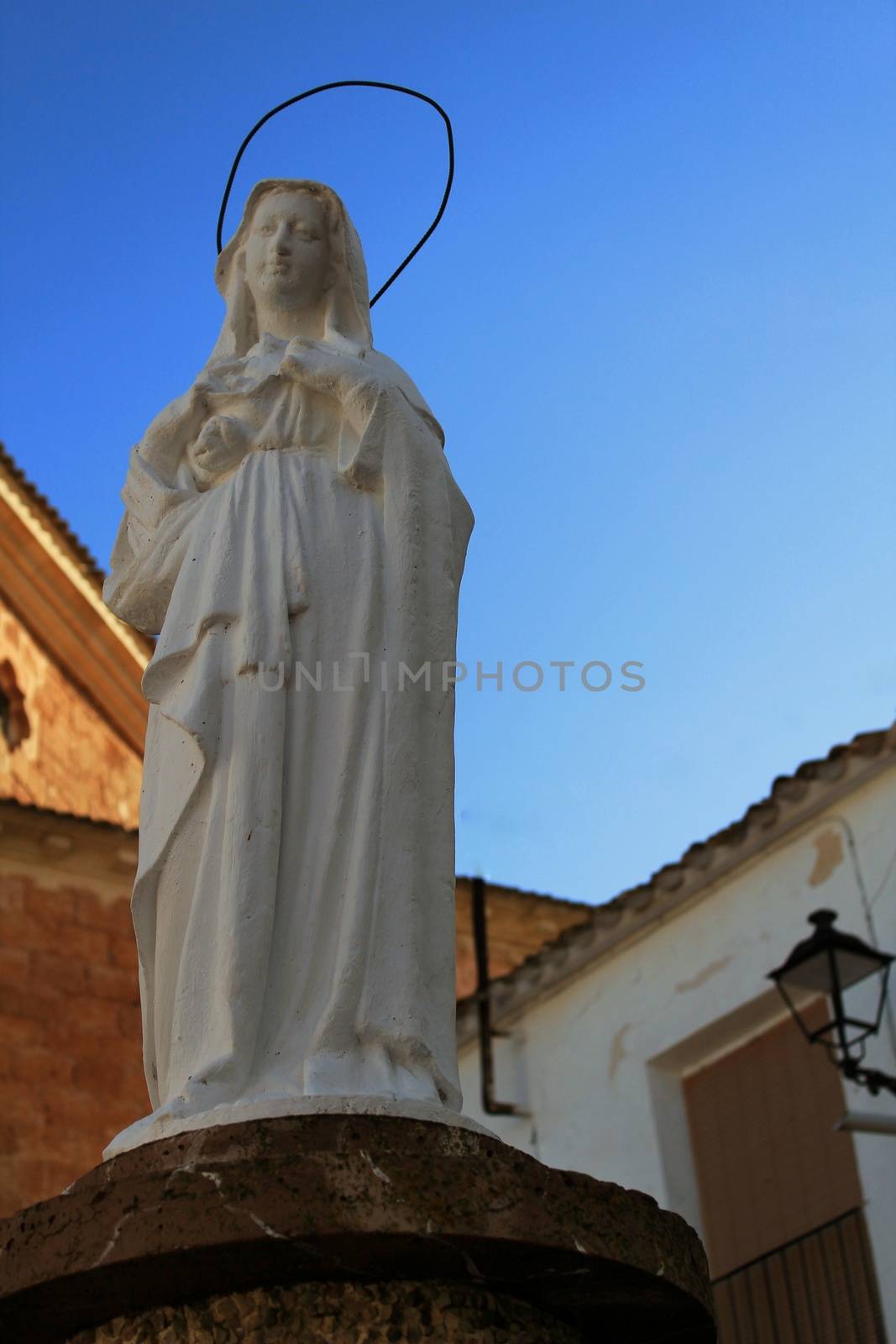 Virgin Mary statue under blue sky in Alborea, Spain by soniabonet