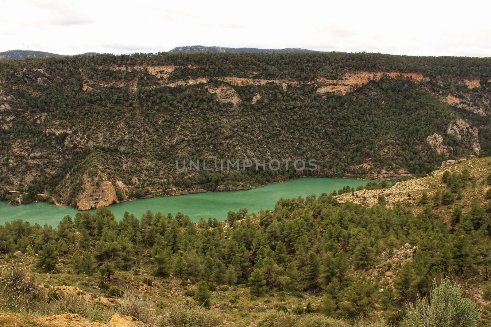 Swamp surrounded by mountains and colorful vegetation in El Molinar, Casas de Ves, Spain. Crystal Clear Waters of Cabriel River