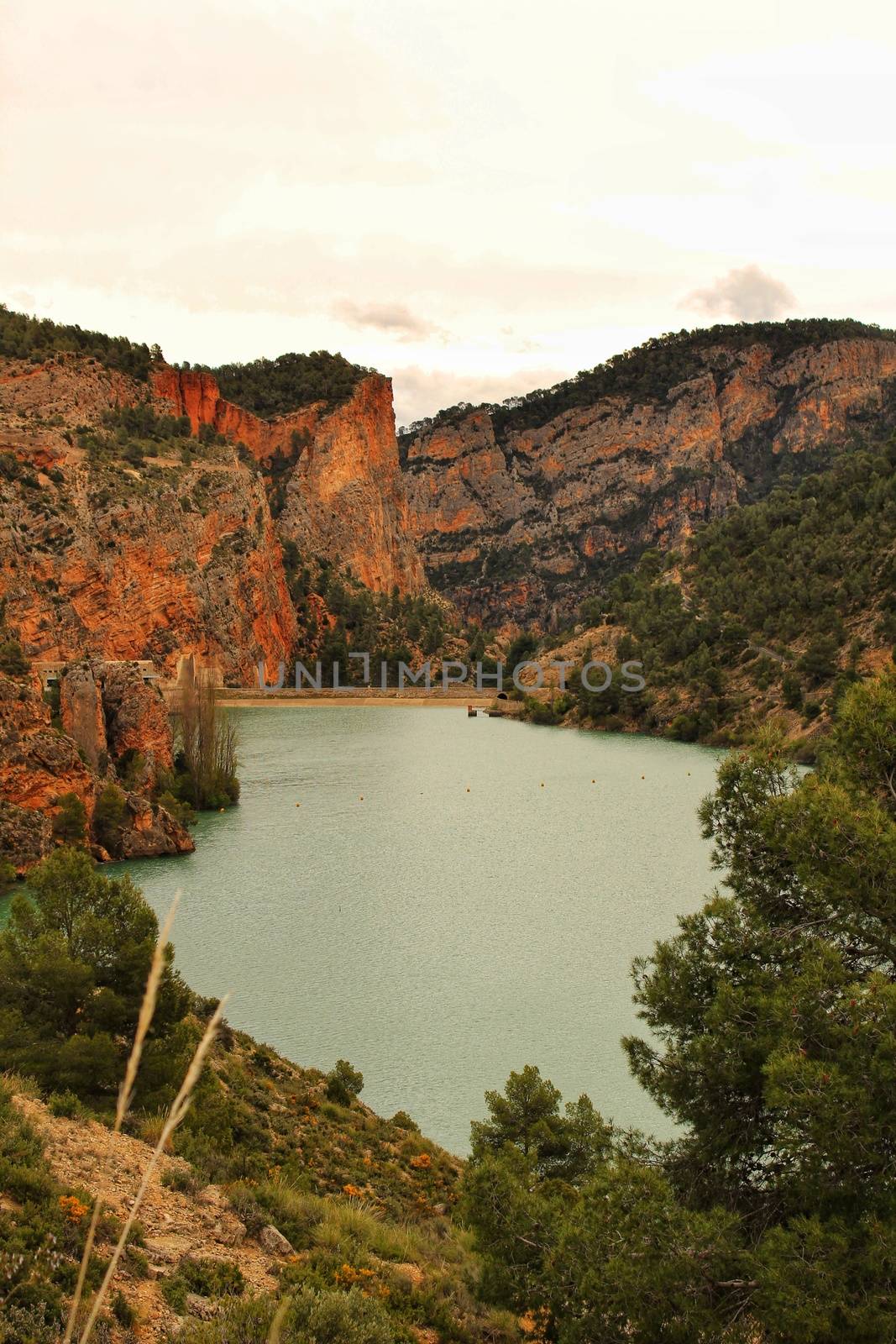 Swamp surrounded by mountains and colorful vegetation in El Molinar, Casas de Ves, Spain. Crystal Clear Waters of Cabriel River