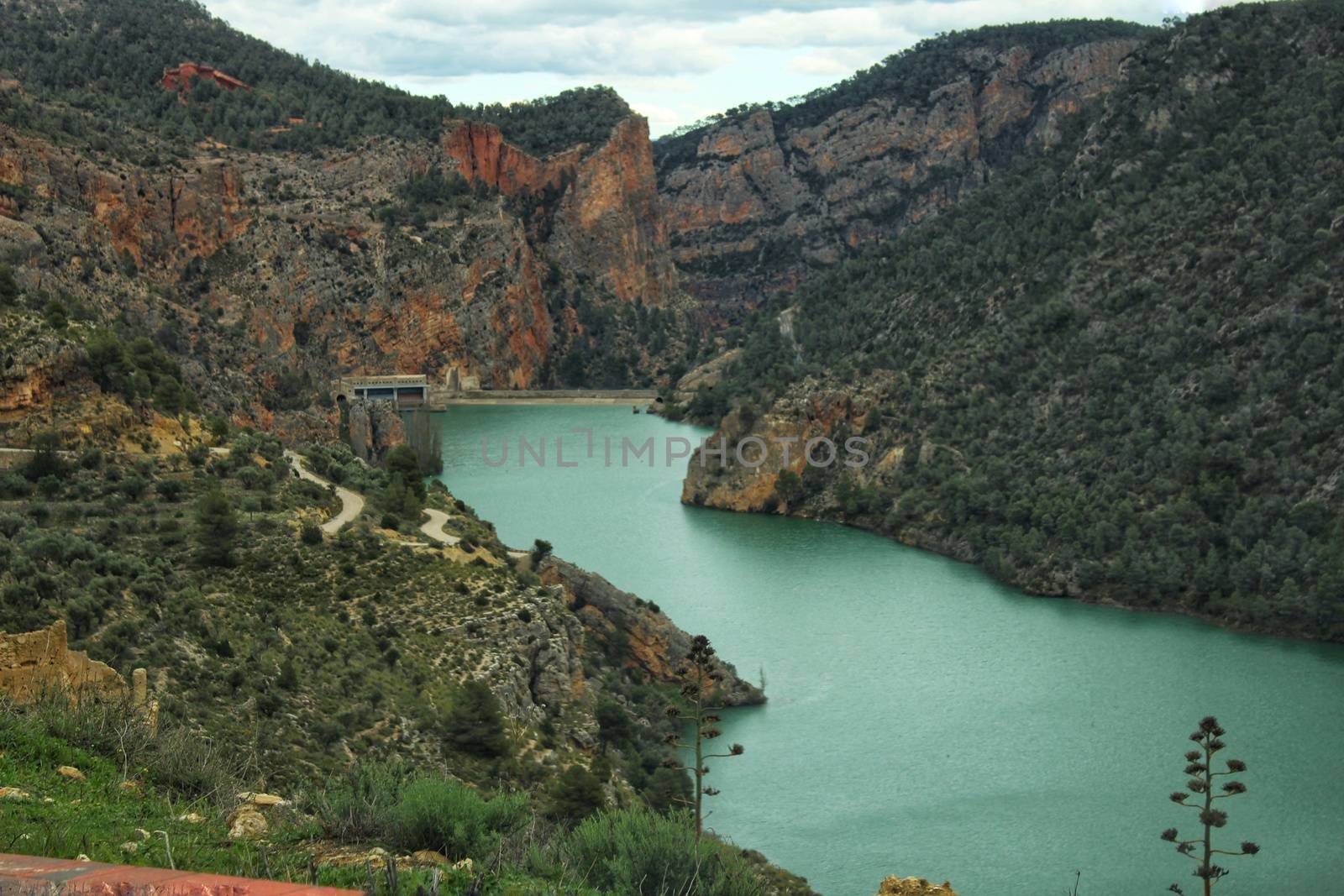 Swamp surrounded by mountains and colorful vegetation in El Molinar, Casas de Ves, Spain. Crystal Clear Waters of Cabriel River