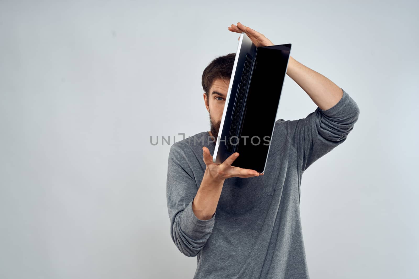 man holding laptop technology internet work communication light background. High quality photo