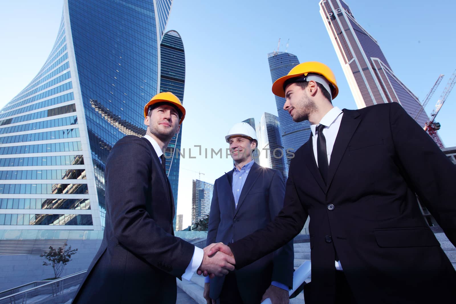 Investor and contractor shaking hands, view from below