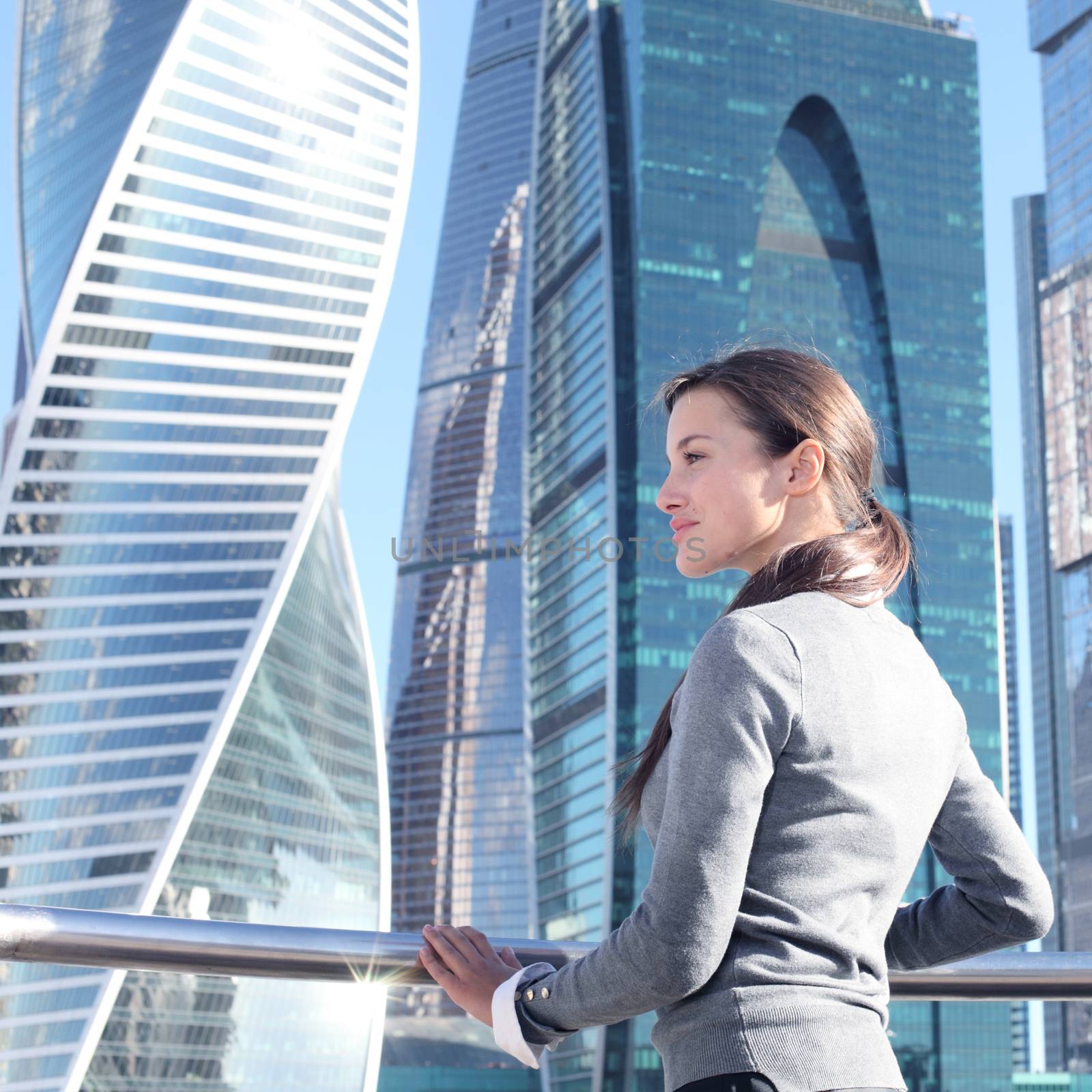 Businesswoman at skyscraper background by ALotOfPeople