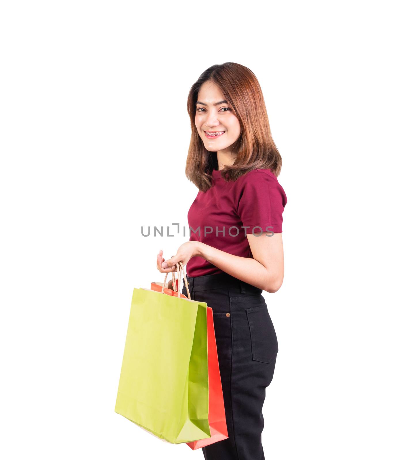 young woman pretty smiling holding paper bags green and orange shopping. isolated on white background and looking at camera