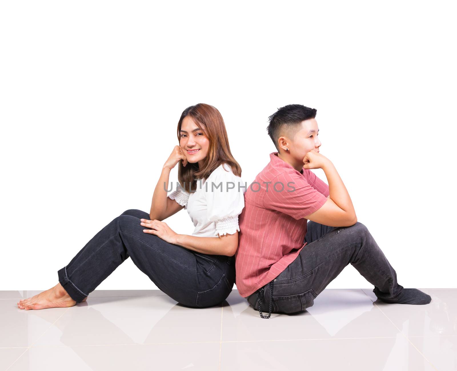 Two smiling woman young girls and happiness tomboy friends sitting back to back on floor with white background