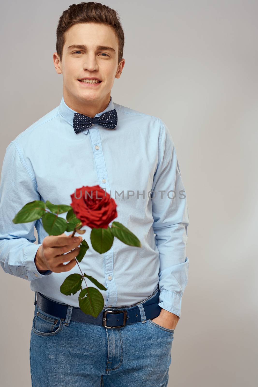 romantic man with red rose and light shirt pants suit. High quality photo