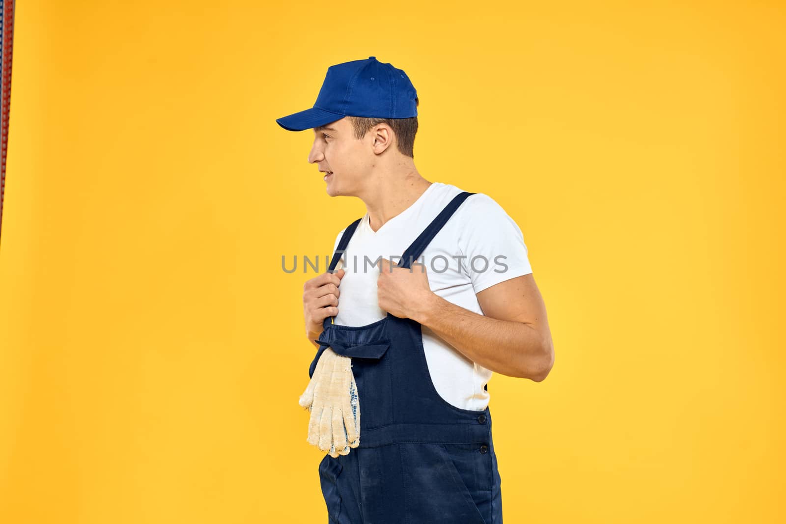 Man in working uniform emotions rendering service delivery service yellow background. High quality photo