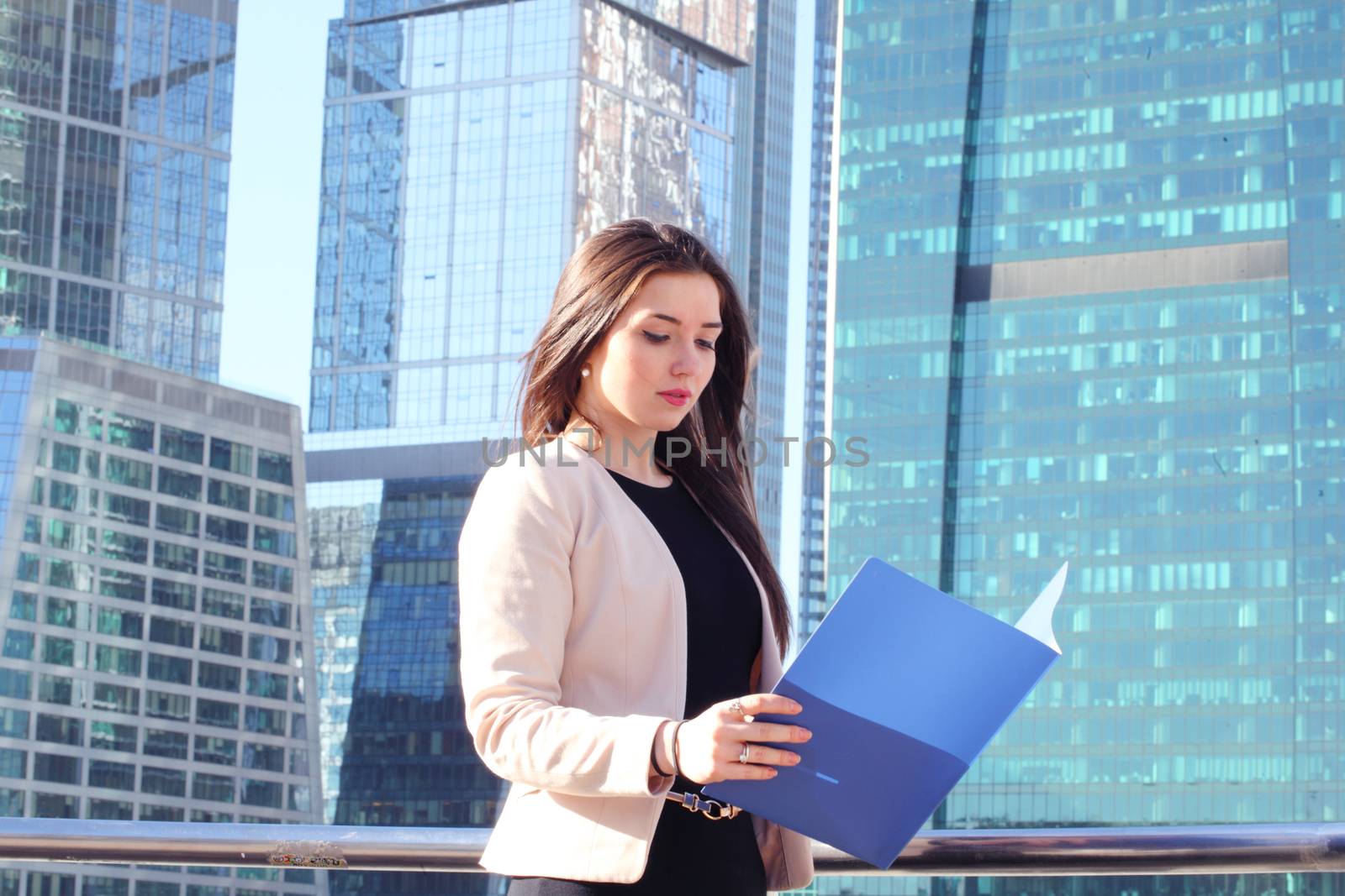 Young beautiful businesswoman outdoors at skyscraper background