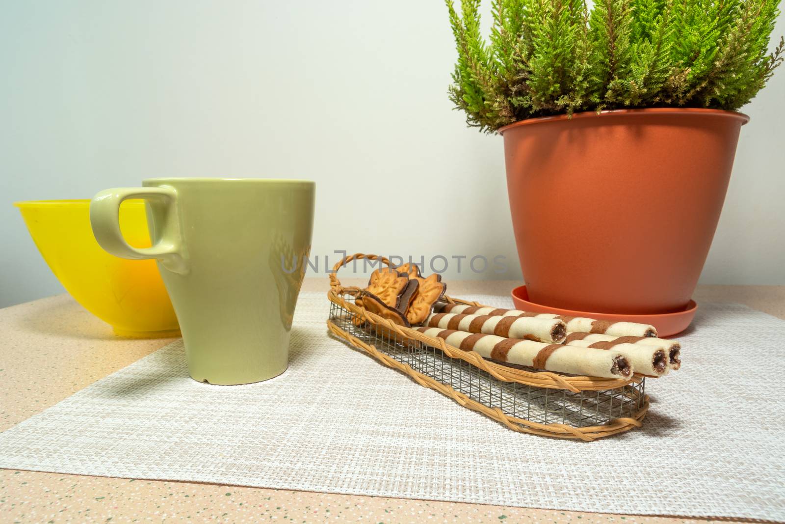 Tubes with cream, green mug and flower in a pot