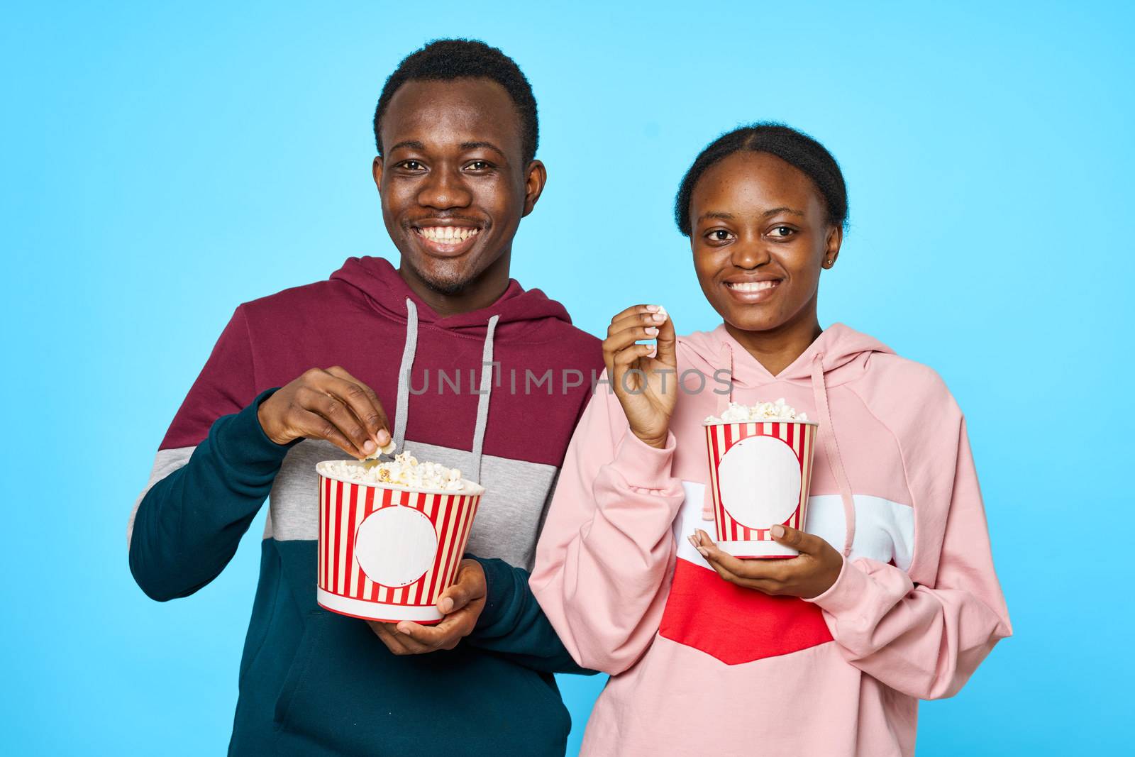 Popcorn watching movies in the cinema African looking man and woman