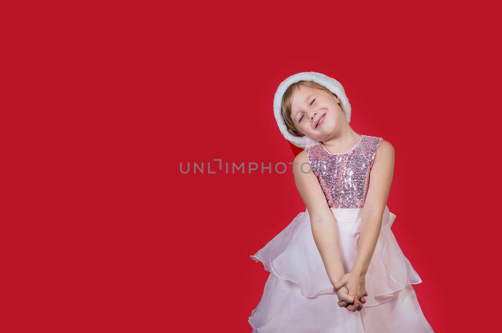 Adorable funny cacusian little girl in santa hat sweetly stretching with her eyes shut celebrating happy New Year isolated on red background. Merry Christmas presents shopping sale.