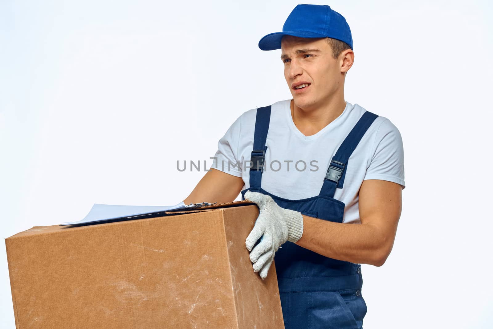 Man worker with box in hands delivery loading service work light background. High quality photo