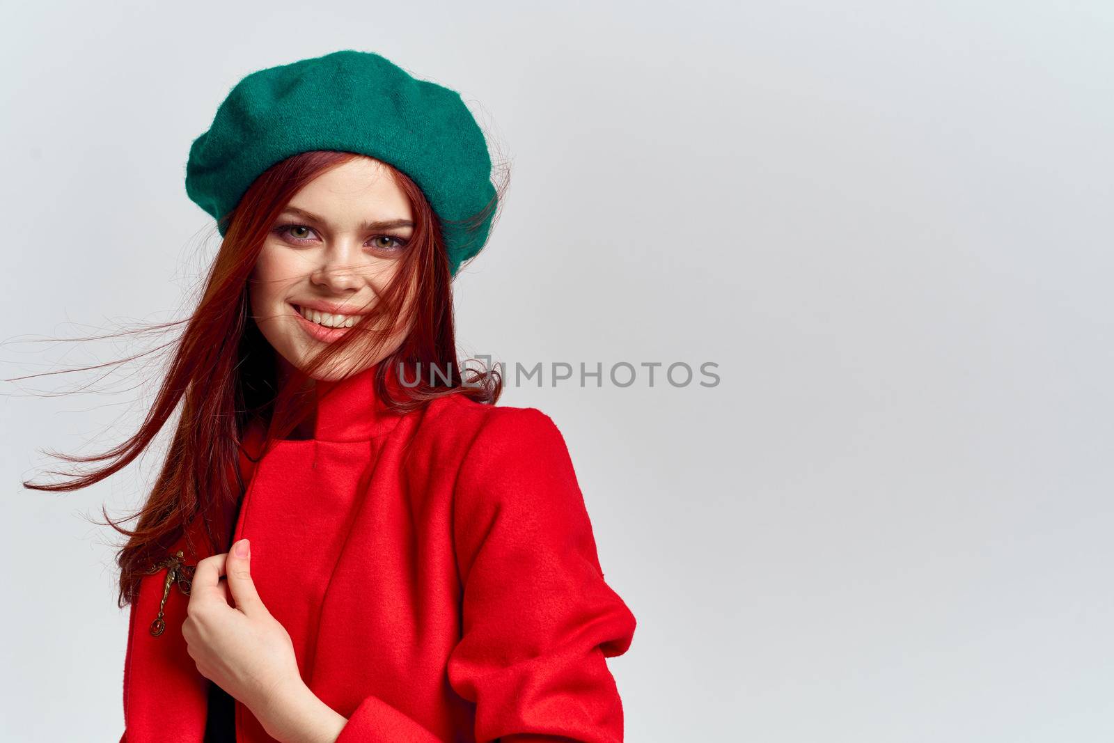 Woman in red coat and in green hat on isolated background cropped model with Copy Space emotions by SHOTPRIME