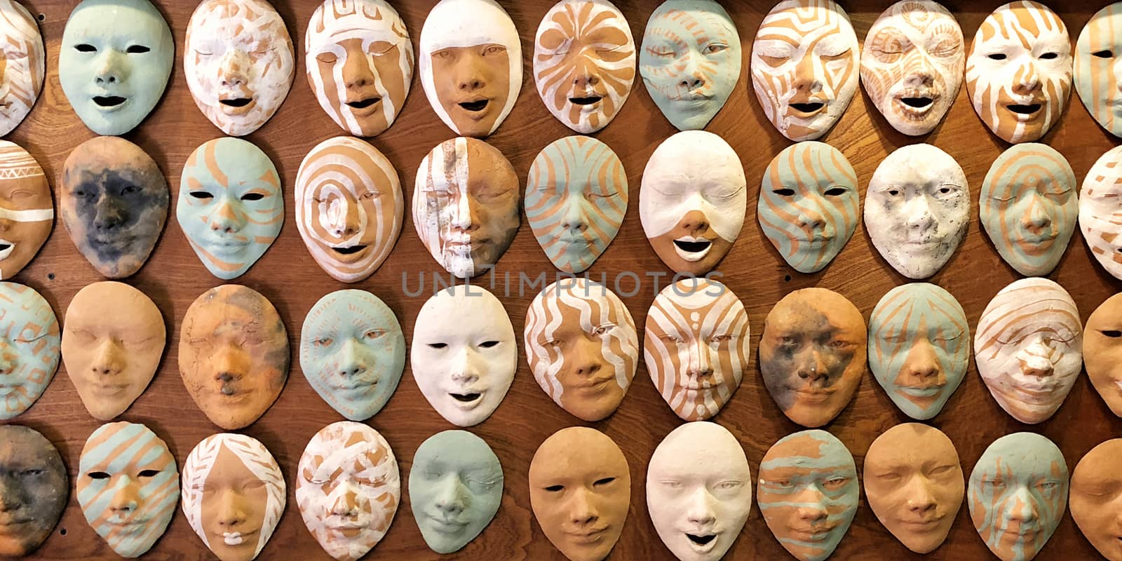 Old masks on wall with different emotional by Surasak