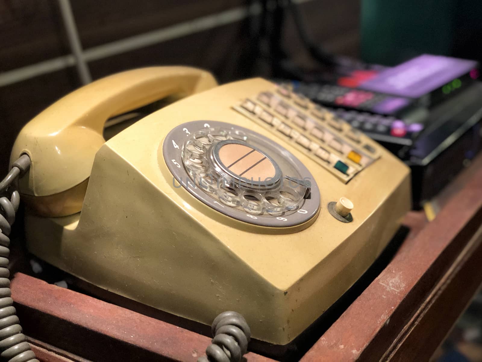 Yellow retro rotary telephone on wood table