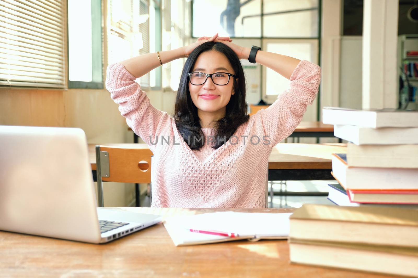 Young woman studying in a library and thinking of something