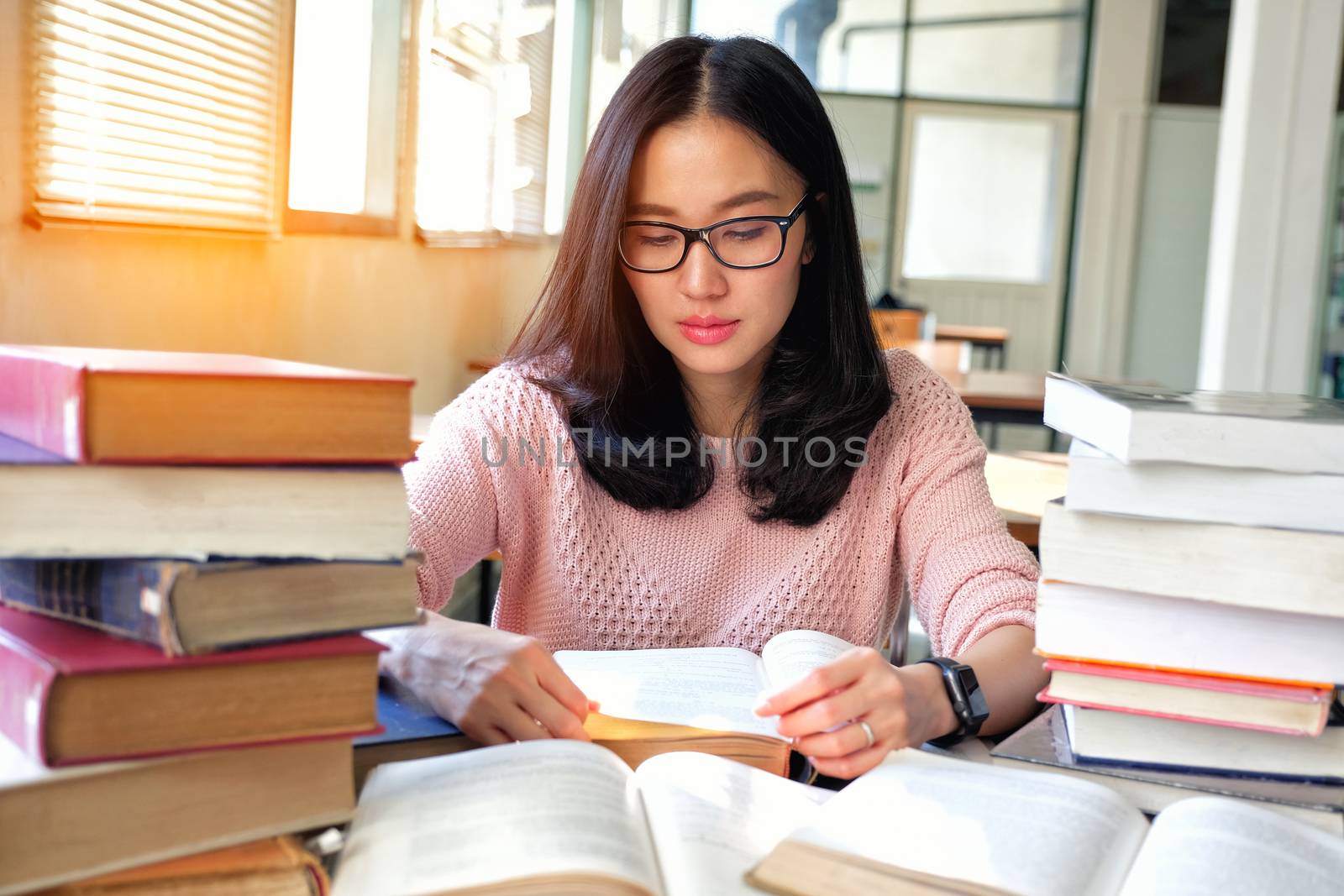 Young woman studying in library by Surasak